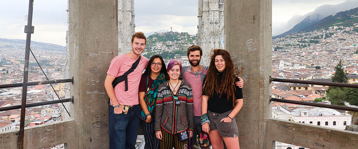 A group of five students stand atop the Quito, Ecuador bell tower