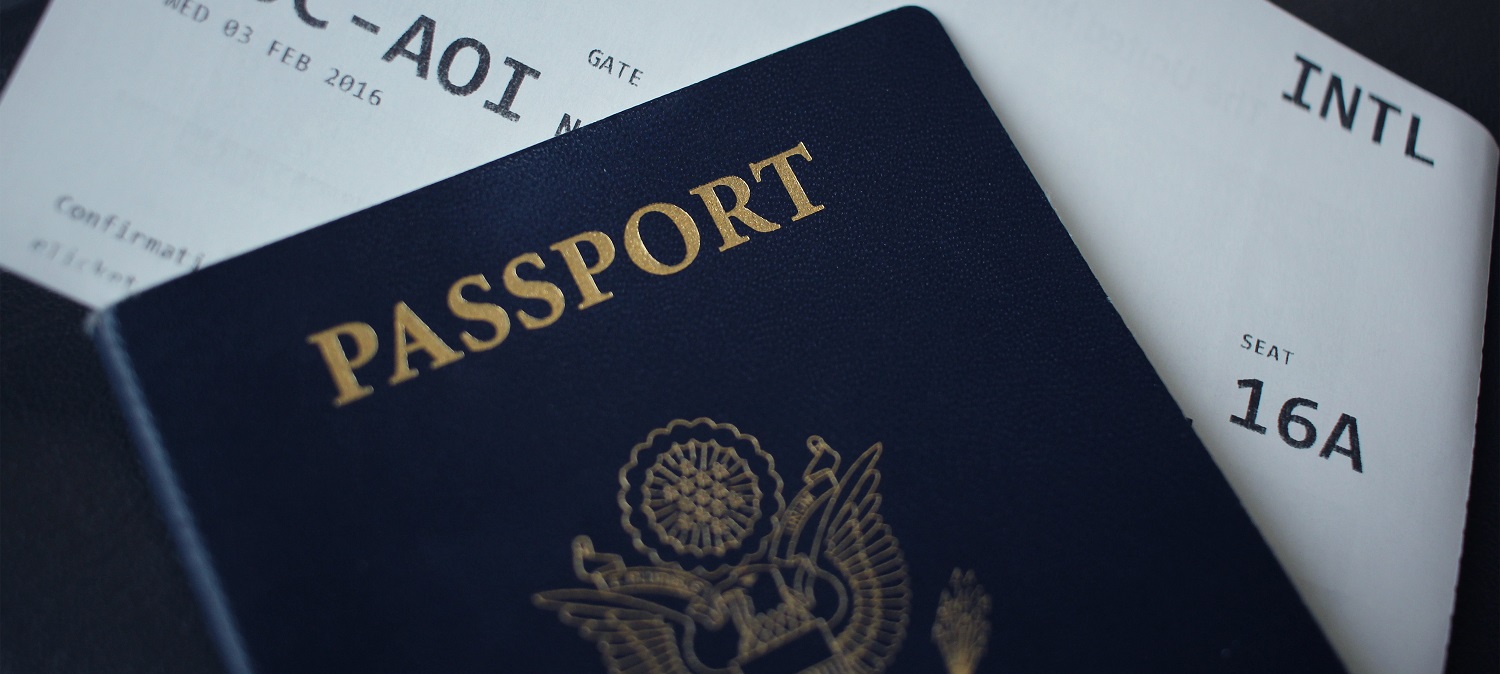 U.S. passport lying on top of a printed airline ticket