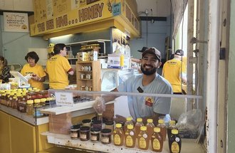 As an ambassador for the Minnesota Honey Producers, Joshua Muñoz offers tastes of local honey at the Minnesota State Fair.